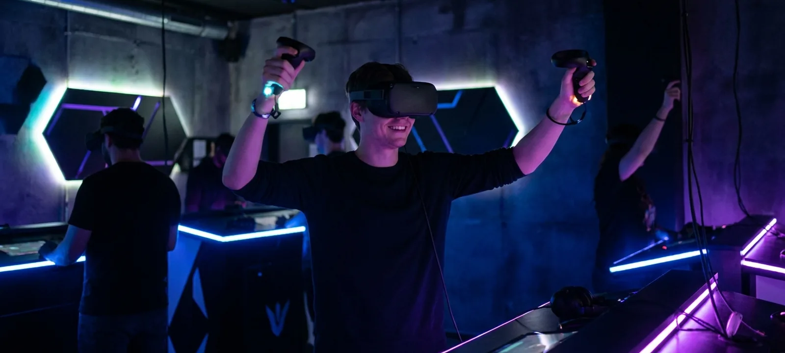 Person mit VR-Brille und Controllern taucht in eine virtuelle Welt ein